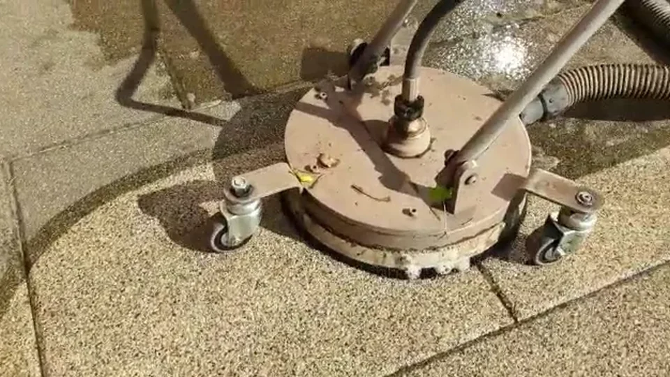 Reinigungsgerät mit Wasserzuführung auf einer Steinplattenfläche