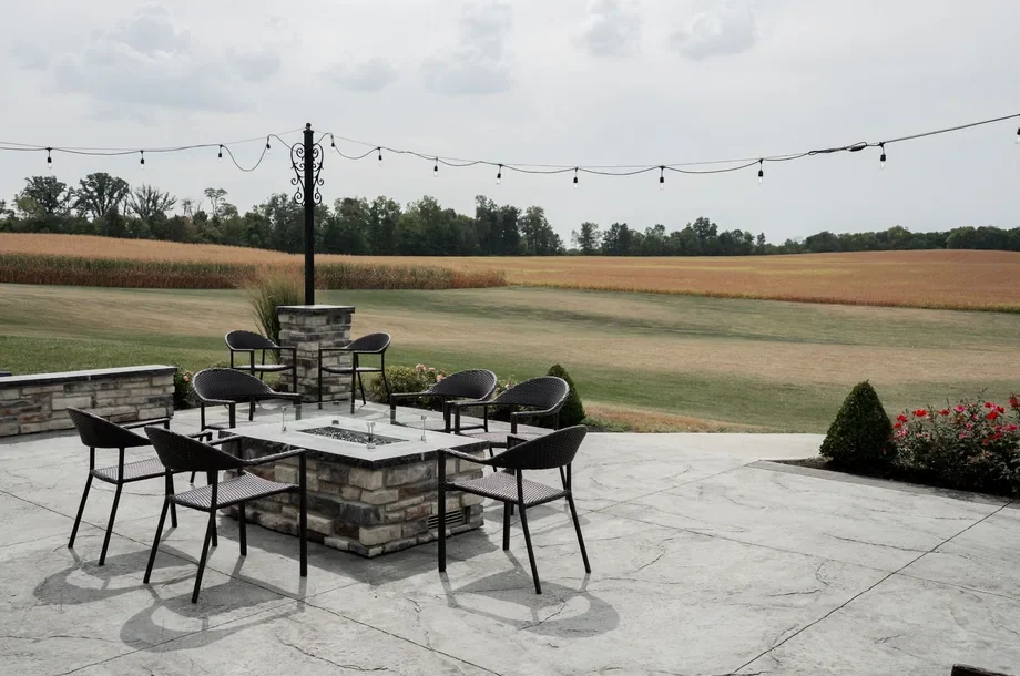 Helle Steinplatten-Terrasse mit Sitzmöbeln und Garten